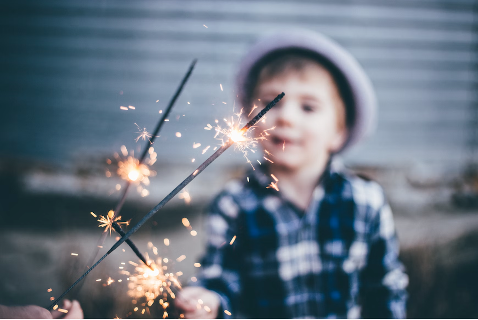 little boy holding a lit sparkler
