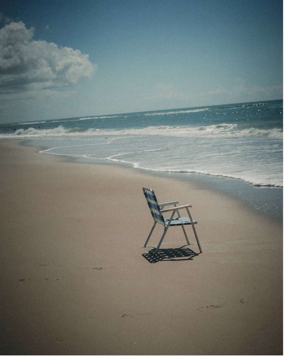 Empty beach chair on the beach sand.