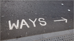 The word WAYS painted on a road with an arrow pointing to the right