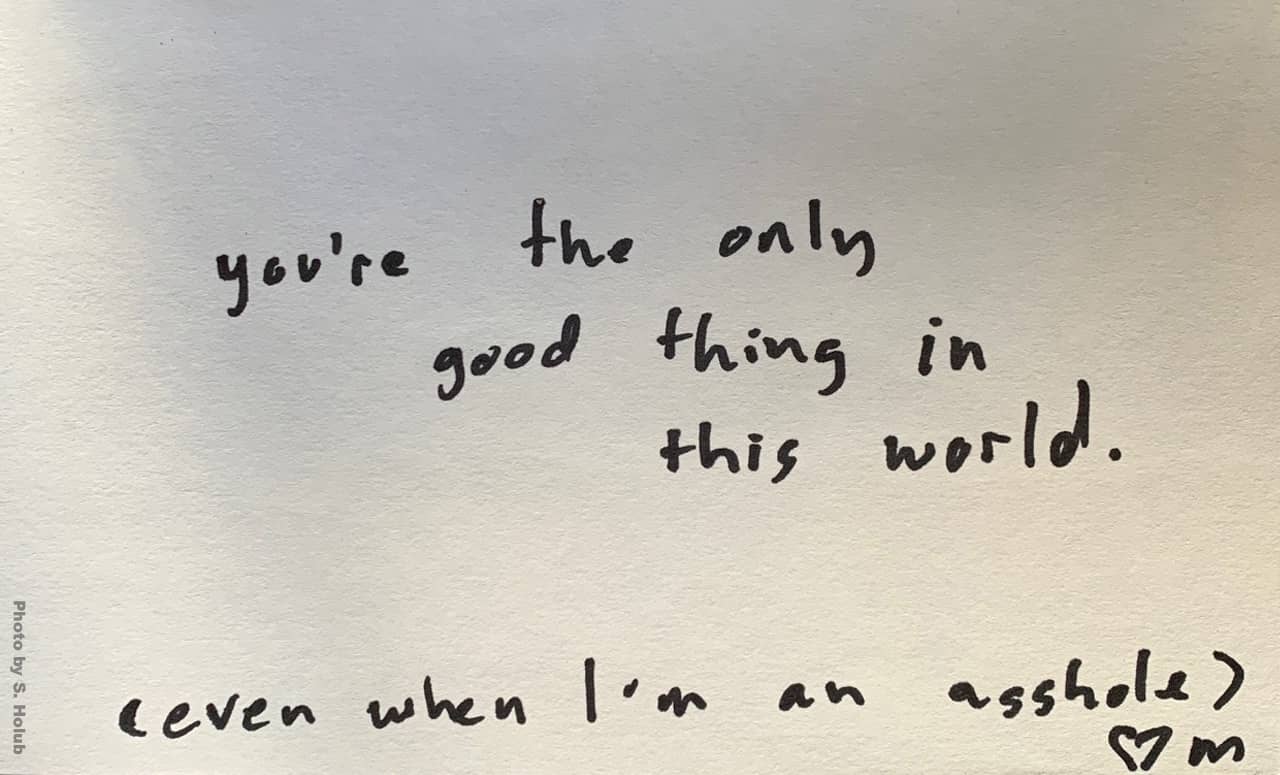 A photo of a card with handwriting that reads, "You're the only good thing in this world. (even when I'm an asshole) - M"