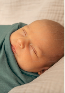 newborn infant swaddled in green blanket