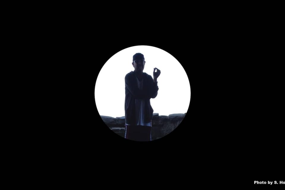 A black background with a circular photo of the silhouette of a person