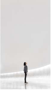 Woman in white space looking up at sky.