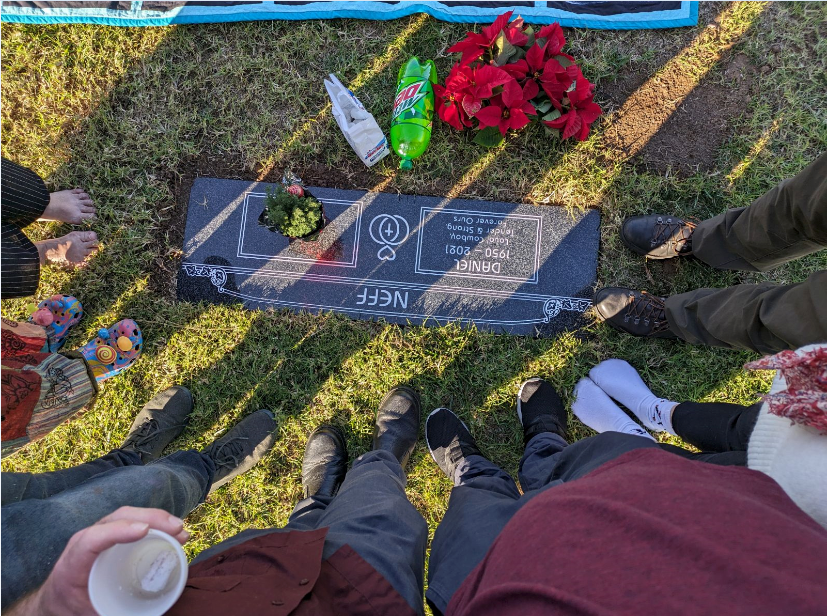 Graveside photo showing feet around the grave.