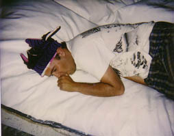 A photo of an art student laying on a mattress of styrofoam.