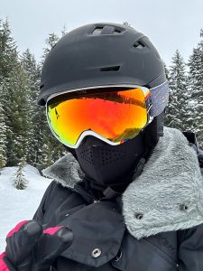 A photo of a snowboarder with helmet and reflective goggles on