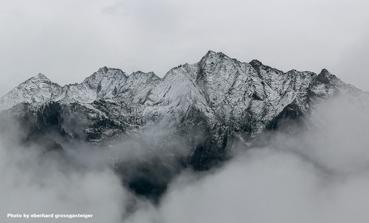 A mountain with snow in the fog