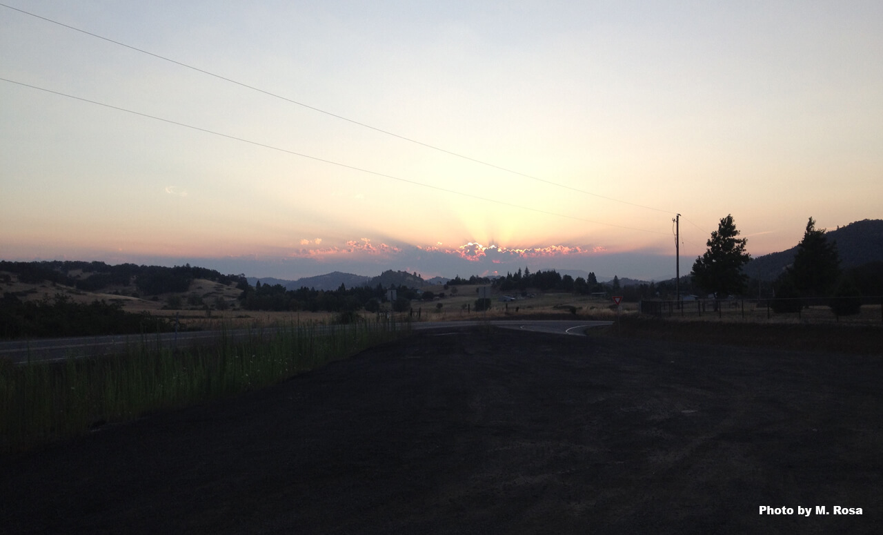 a morning sunrise as seen over fields in a rural area