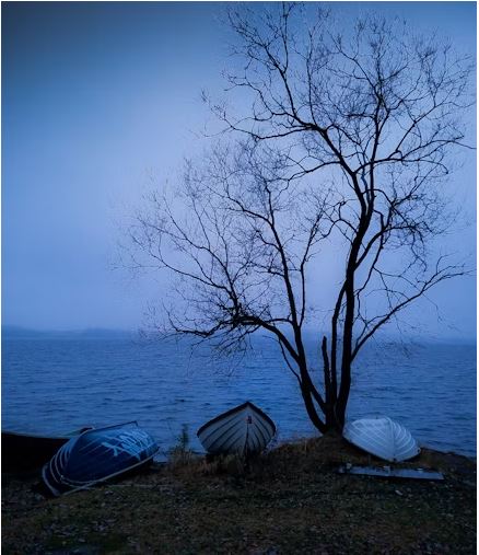 Three boats waiting at water's edge.