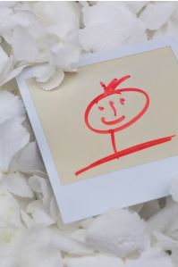 Photo of red happy face in rose petals.