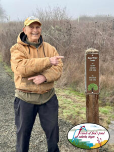 Tony Rosa stands next to a trail head dedicated to him and his volunteer work