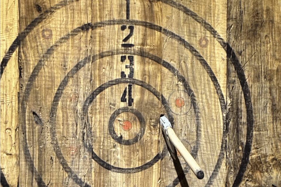 an axe thrown into a wood target
