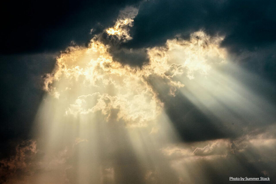 sun rays shining through dark clouds