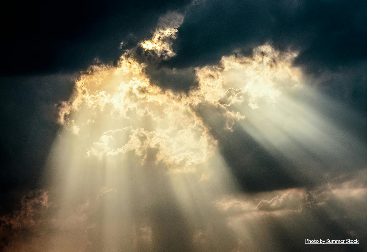 sun rays shining through dark clouds
